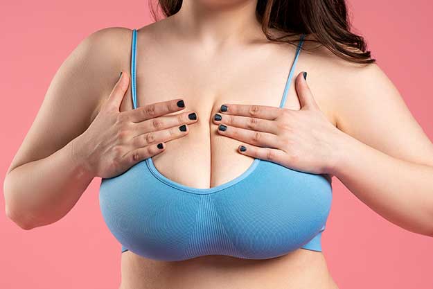 mulher sentindo incômodo com tamanho dos seios sendo candidata à cirurgia de redução de mamas