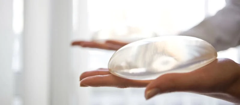 Cirurgião plástico com silicione na mão para o procedimento de expansão tecidual