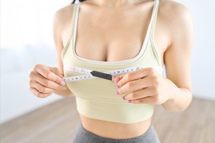 Mulher mostrando cirurgia de redução mama antes e depois