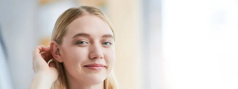 Moça loira feliz depóis do seu procedimento de otoplastia