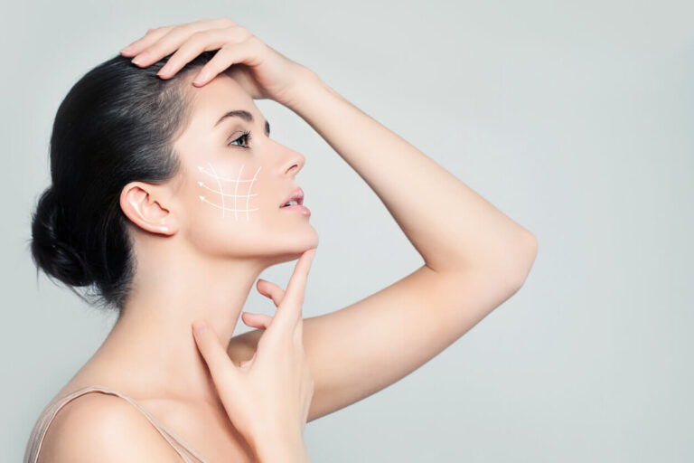 Mulher de perfil tocando o rosto, com linhas brancas desenhadas na bochecha, representando tratamento estético para corrigir assimetria facial.
