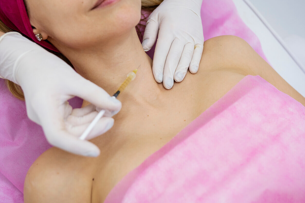 plicação de botox no pescoço e colo feita por profissional com luvas, durante procedimento estético em clínica.