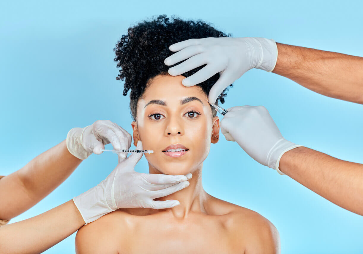 Mulher recebendo aplicações de botox e preenchimento facial com profissionais utilizando luvas e seringas, representando procedimentos estéticos seguros e modernos.