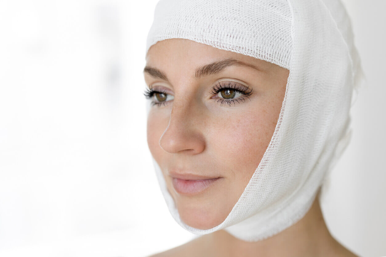 mulher com curativo envolvendo o rosto no período de recuperação, representando o pós-operatório do deep plane