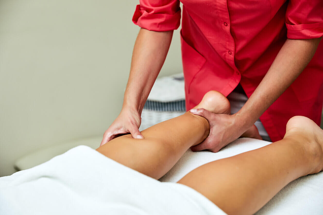 Profissional realizando drenagem linfática nas pernas como parte do tratamento para lipedema