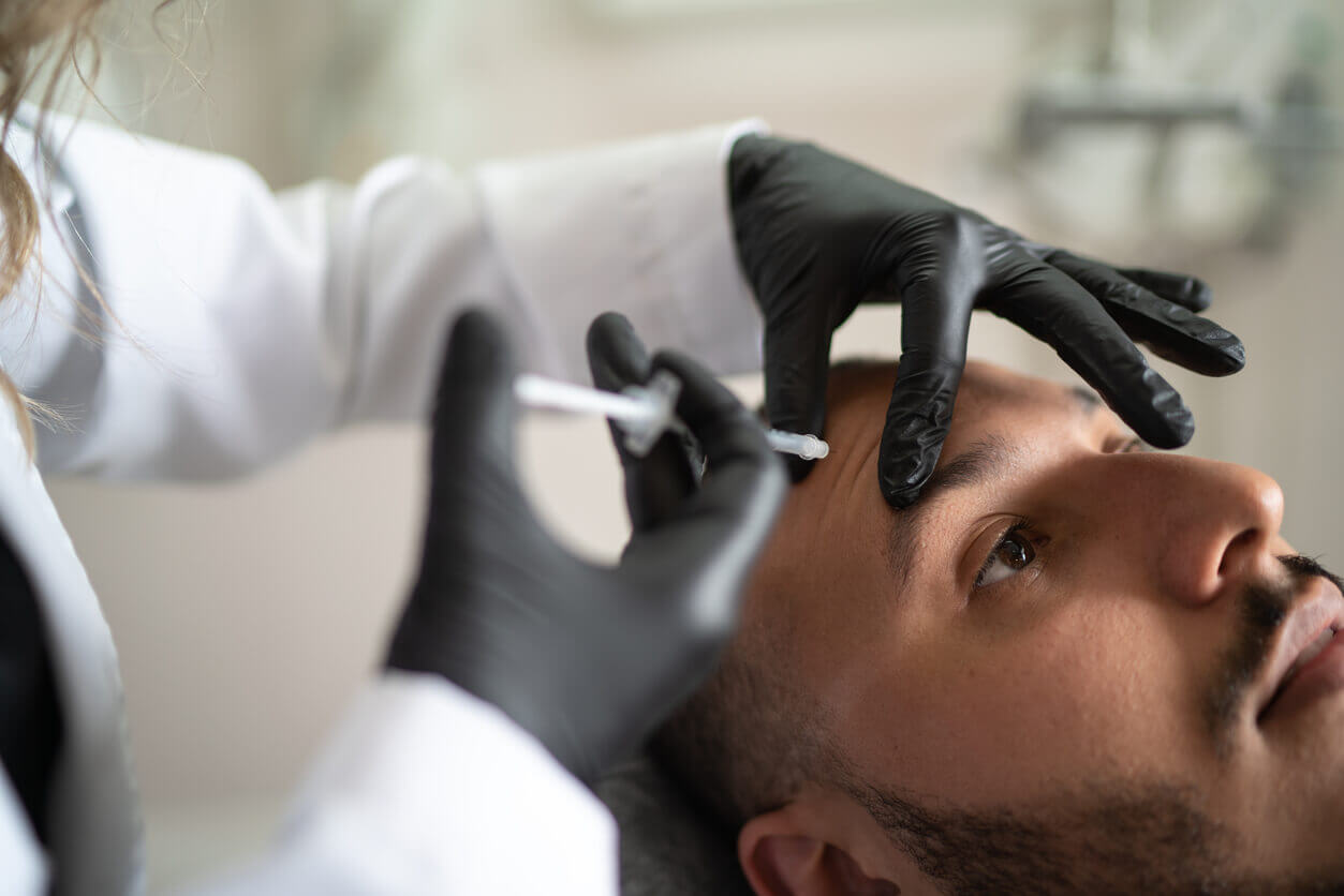 Procedimento de botox masculino sendo aplicado na região da testa, destacando os cuidados com a estética facial masculina e a busca por resultados naturais