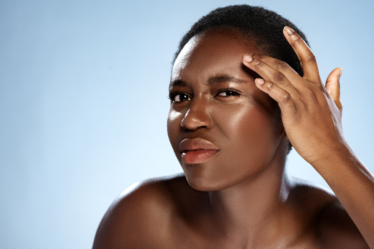 Mulher observando sinais de envelhecimento no rosto, como linhas e flacidez, que podem ser tratados com lifting facial