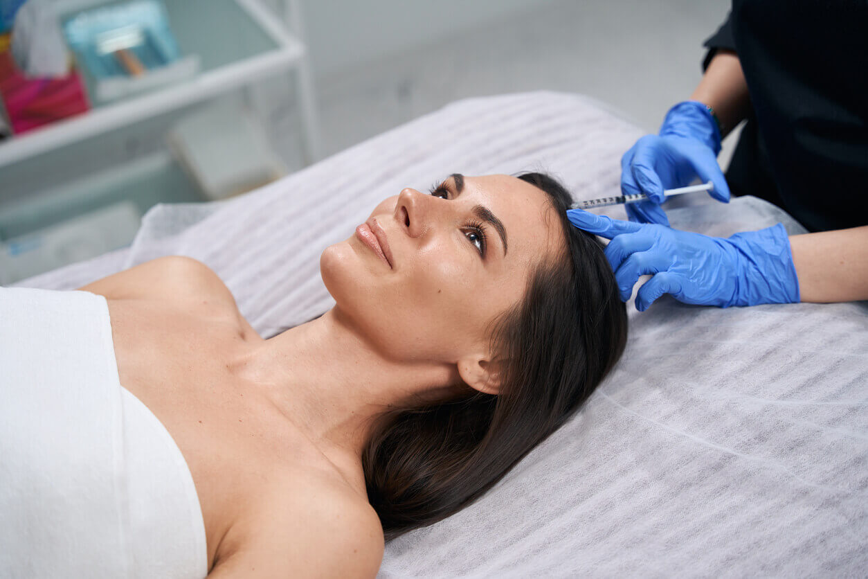 Aplicação em uma das áreas de aplicação do botox no couro cabeludo durante procedimento estético em clínica especializada