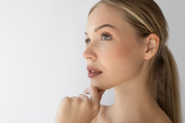 Mulher com pele jovem e uniforme após cuidados estéticos como resurfacing facial