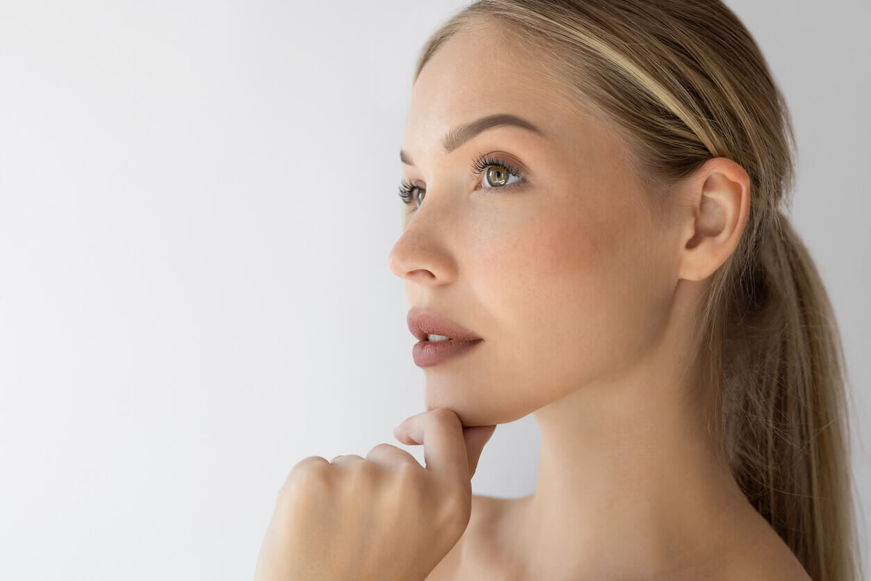 Mulher com pele jovem e uniforme após cuidados estéticos como resurfacing facial