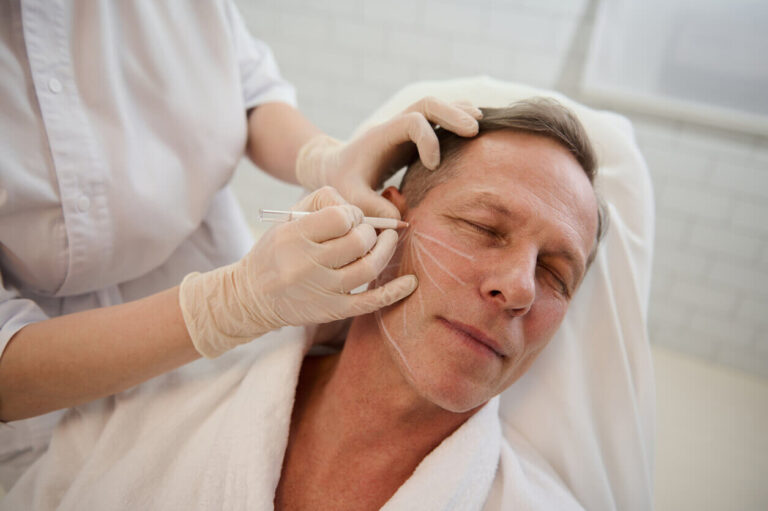 Homem realizando marcação facial para cirurgia deep plane em clínica estética.
