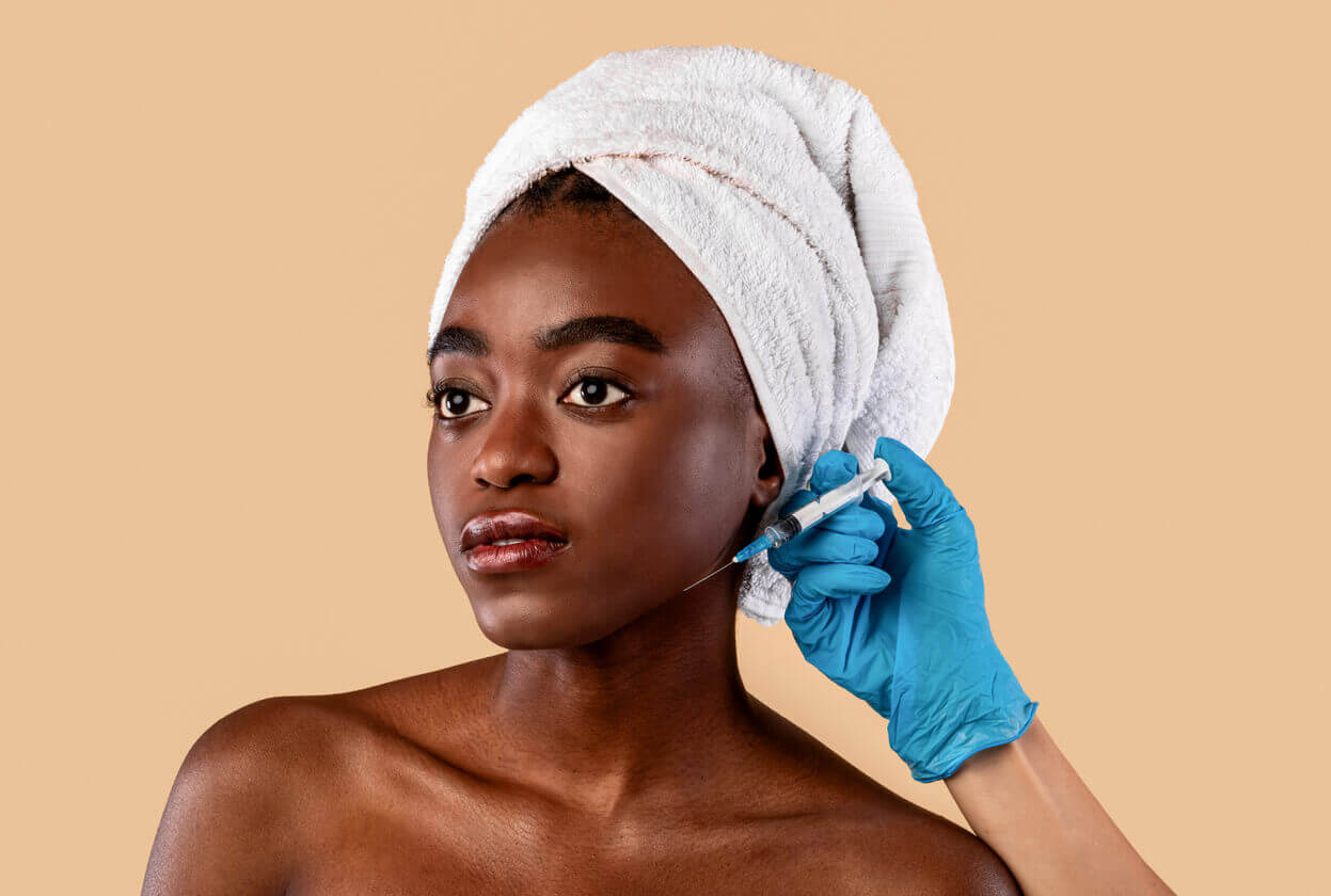 Mulher se preparando para realizar um procedimento estético facial com aplicação próxima ao rosto