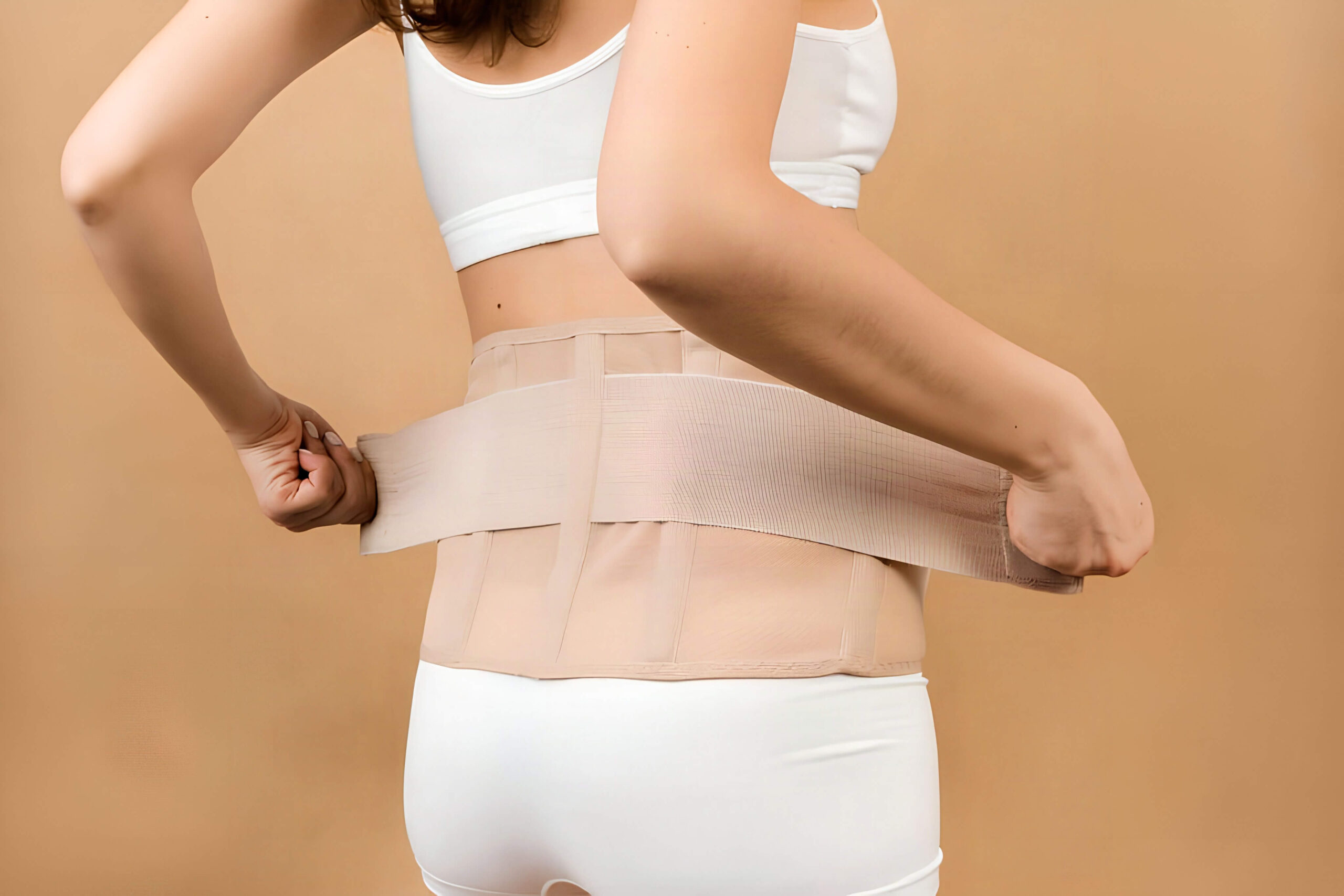 Mulher usando cinta após cirurgia reparadora pós-bariátrica para auxiliar na recuperação abdominal