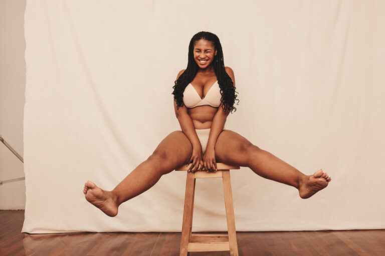 Mulher sentada com as pernas em destaque, ilustrando conteúdo sobre doença lipedema, distribuição de gordura e dificuldade de emagrecimento.