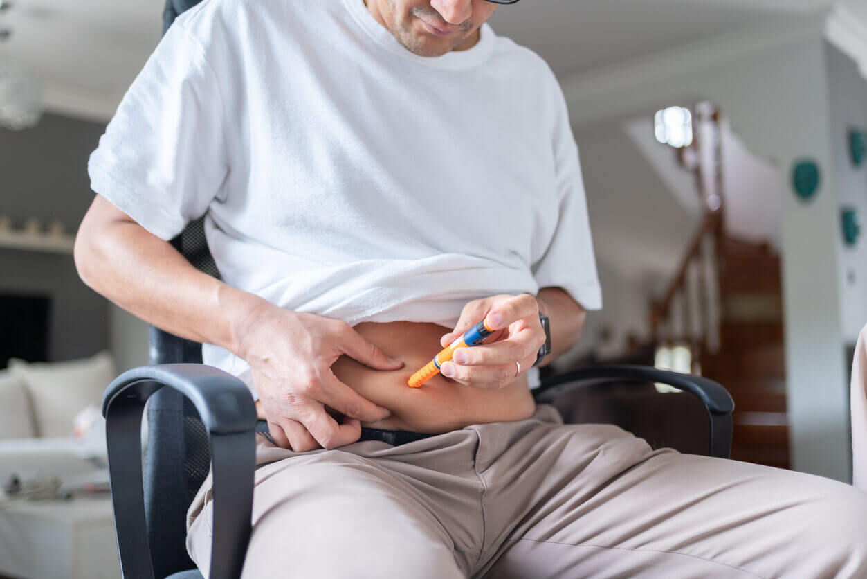 Homem aplicando caneta emagrecedora na região abdominal, em conteúdo sobre flacidez masculina após a perda de peso.
