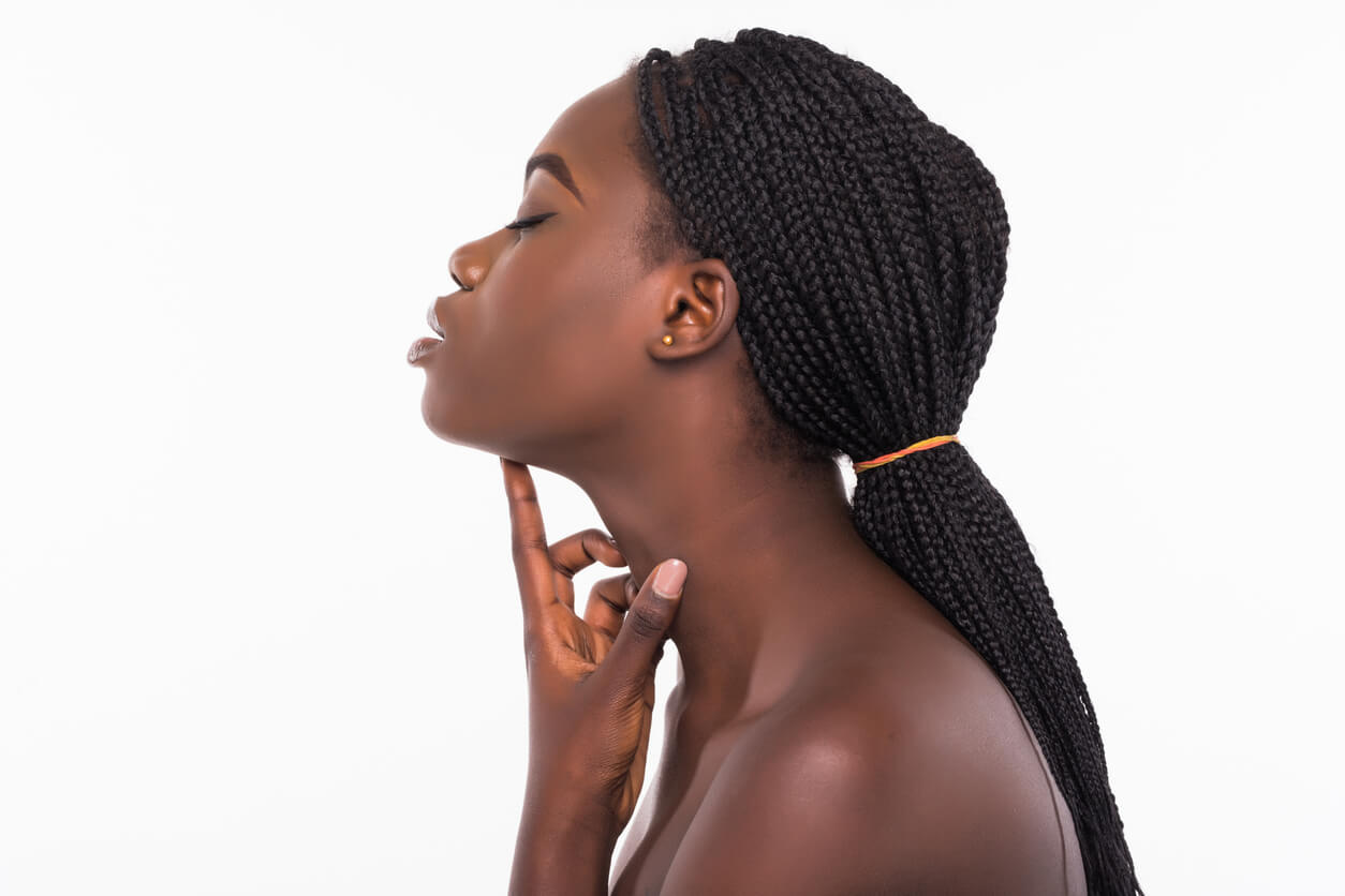 Mulher de perfil com a mão apoiada abaixo do queixo, destacando a região do pescoço e ilustrando como diminuir a papada após o emagrecimento.