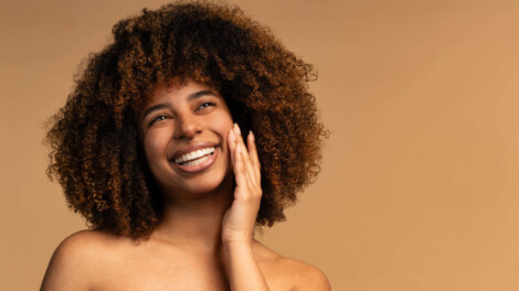 Mulher sorrindo durante cuidados faciais relacionados à cirurgia plástica da face