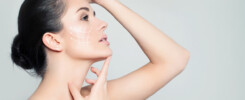 Mulher de perfil tocando o rosto, com linhas brancas desenhadas na bochecha, representando tratamento estético para corrigir assimetria facial.