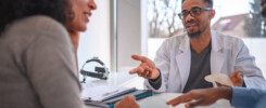 Cirurgião plástico conversando com paciente sobre lifting de mamas, explicando a diferença entre a cirurgia com e sem prótese