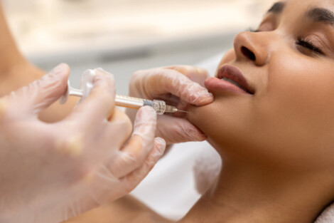 Profissional aplicando preenchimento no rosto na região do queixo para harmonizar os traços e realçar a beleza facial.